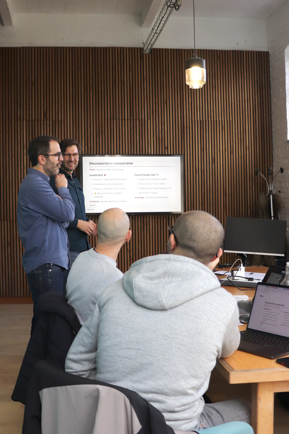 Bootcamp Hoko : deux formateurs présentent une démonstration comparative entre Lovable et Claude Code devant les participants.
